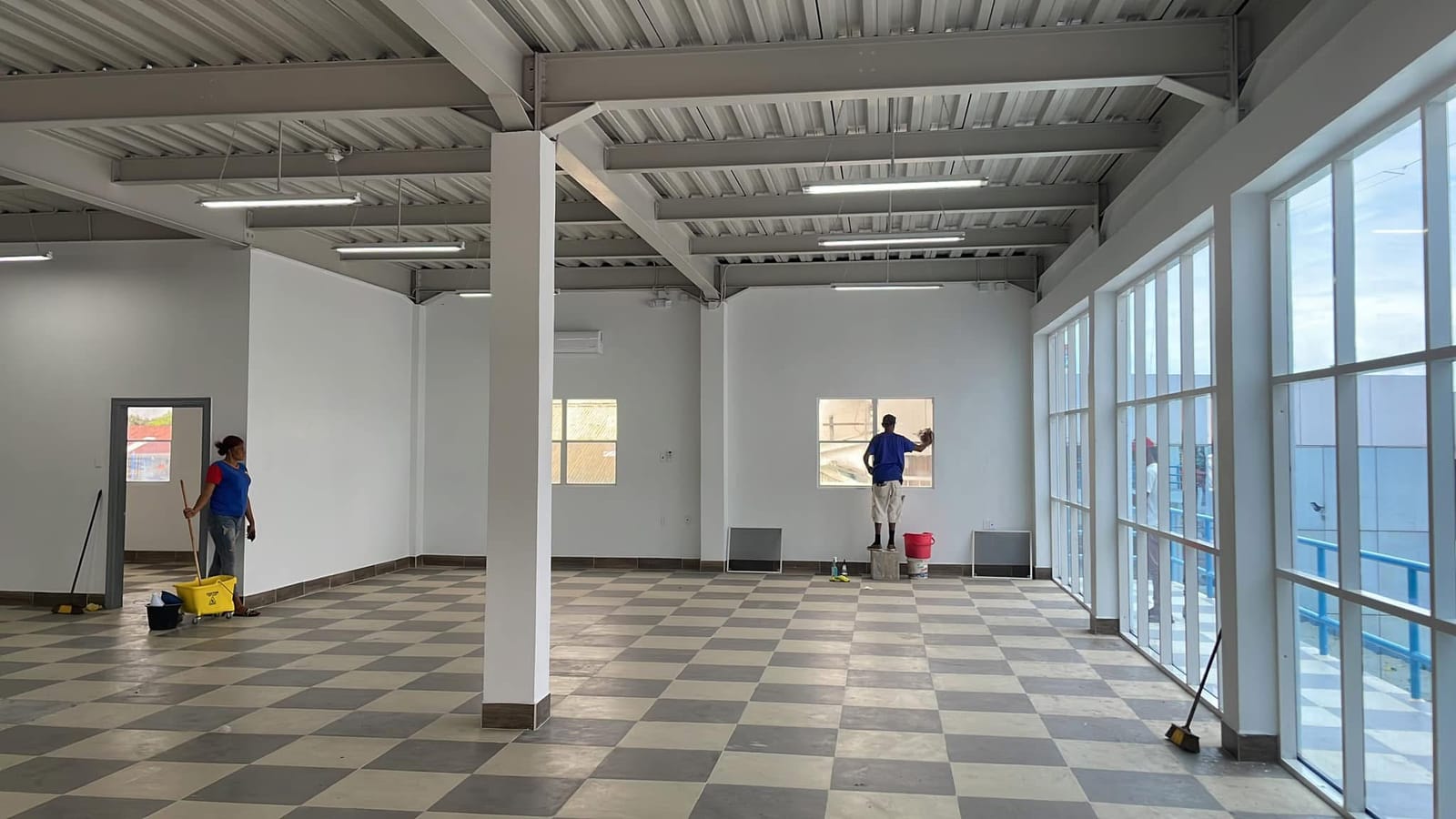 CDCS cleaning team mopping the floor and cleaning windows inside a large commercial building in Guyana