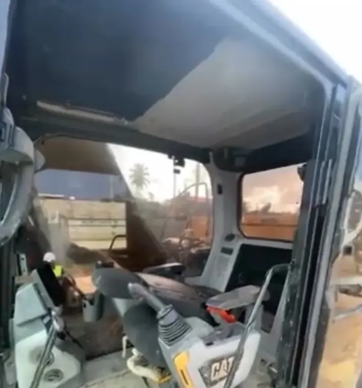 The dusty operator cab of an excavator on a work site in Guyana, ahead of interior cleaning by CDCS